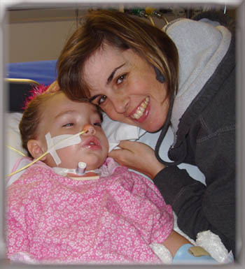 After she got her tracheostomy, we were overjoyed to see her face again. PICU, May 2004